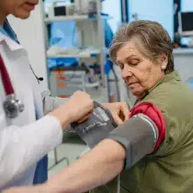 Nurse checking blood pressure of senior