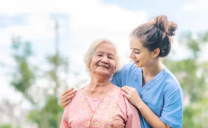Caregiver with elderly woman outdoors