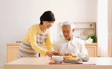 caregiver serving food on table to senior