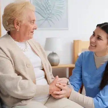 Caregiver holding senior women hand