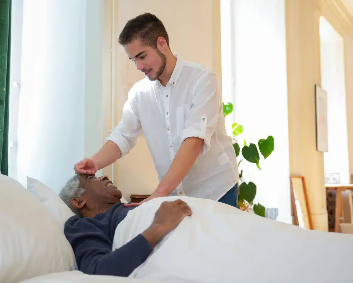 young caregiver measuring temperature with his hand